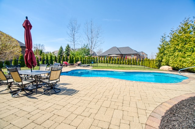 view of swimming pool with a patio area, a fenced in pool, and fence