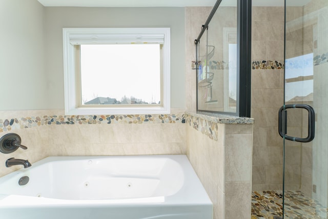 bathroom featuring a tub with jets and a stall shower