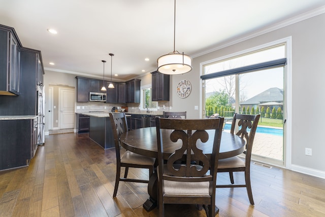 dining room featuring visible vents, crown molding, baseboards, and dark wood-style flooring