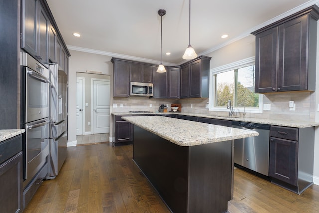 kitchen with dark brown cabinets, ornamental molding, a sink, appliances with stainless steel finishes, and dark wood-style flooring