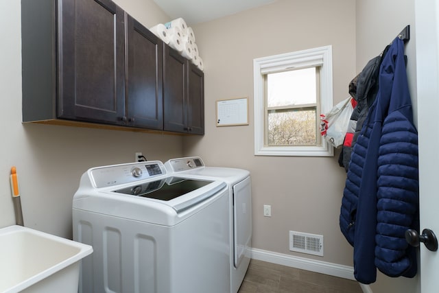 washroom with visible vents, a sink, independent washer and dryer, baseboards, and cabinet space