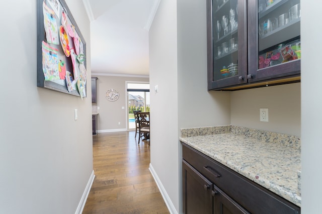 bar with baseboards, ornamental molding, and dark wood finished floors