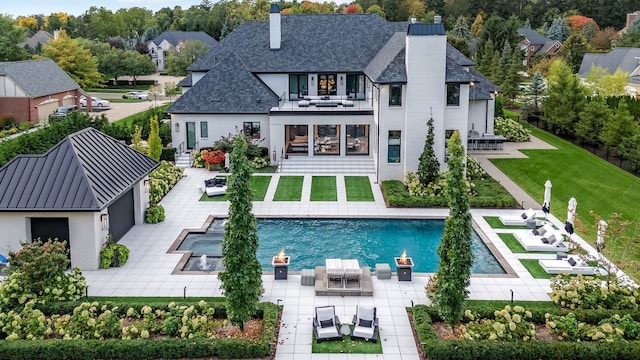 rear view of house with a lawn, an outdoor living space, a balcony, and a patio