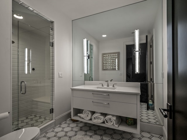 bathroom featuring vanity, toilet, and an enclosed shower