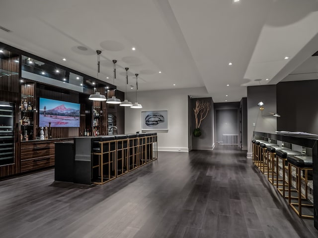 bar featuring decorative light fixtures and dark hardwood / wood-style floors