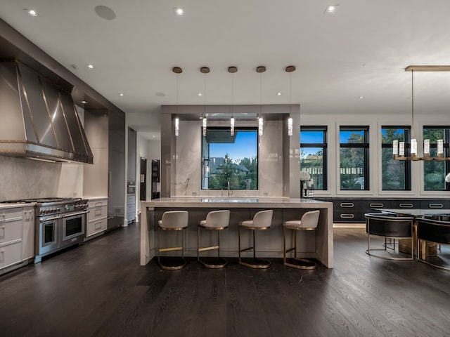 kitchen featuring decorative light fixtures, double oven range, dark hardwood / wood-style floors, and a kitchen island