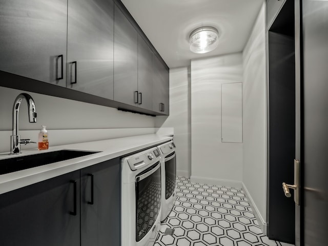 clothes washing area with cabinets, sink, and washer and dryer