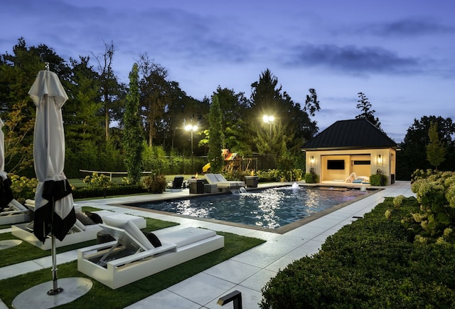 view of swimming pool with pool water feature and an outdoor structure