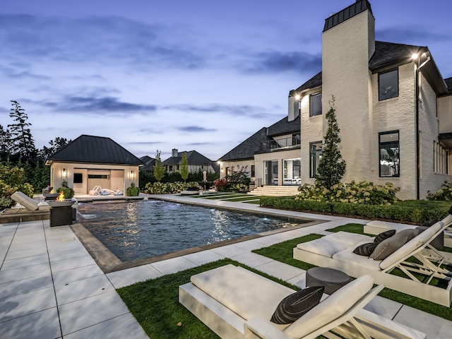 view of pool featuring pool water feature and a patio