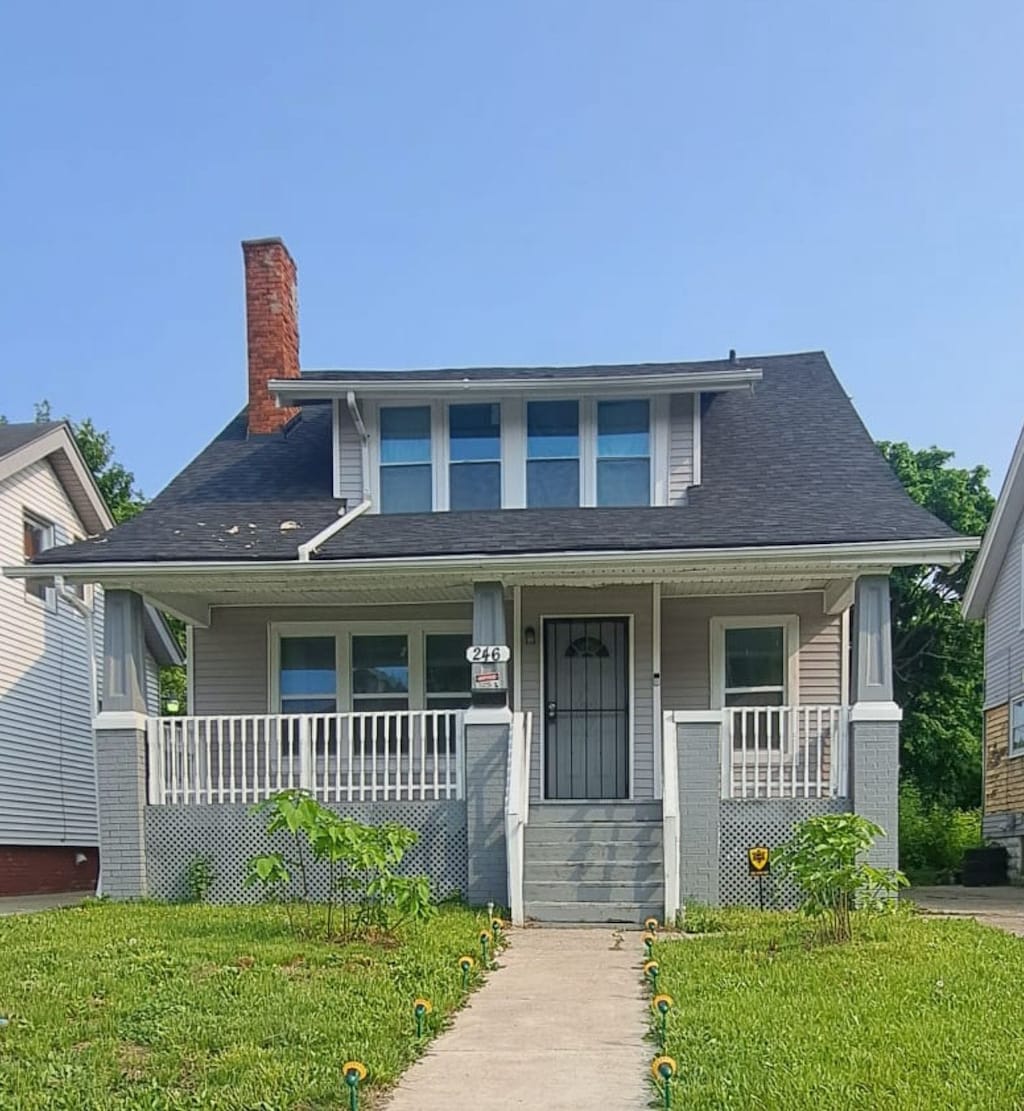 view of front of home with covered porch and a front yard