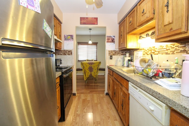 kitchen with white dishwasher, black range with electric stovetop, decorative light fixtures, light hardwood / wood-style floors, and stainless steel refrigerator