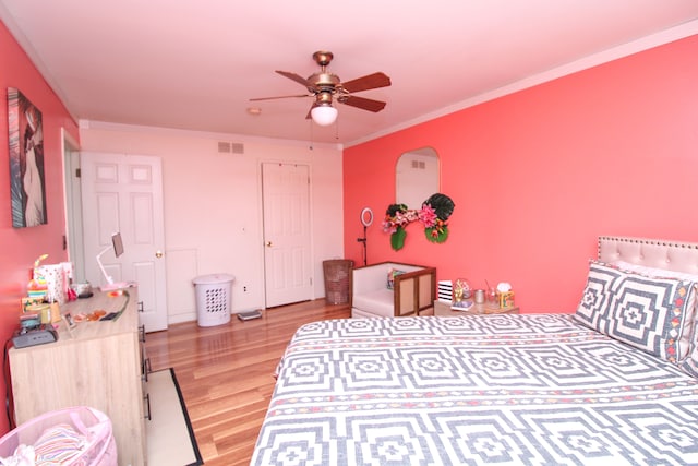 bedroom featuring ceiling fan, light wood-type flooring, and crown molding