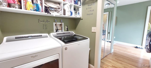 clothes washing area featuring washing machine and clothes dryer and light hardwood / wood-style flooring