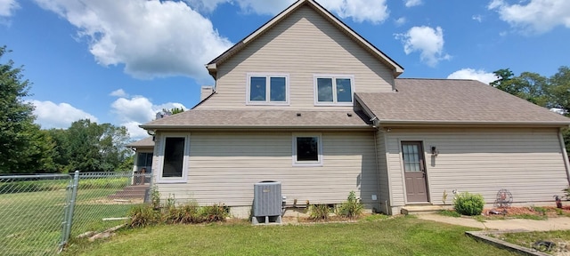 rear view of house featuring a yard and central AC