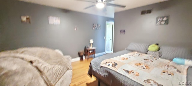 bedroom with light hardwood / wood-style floors and ceiling fan