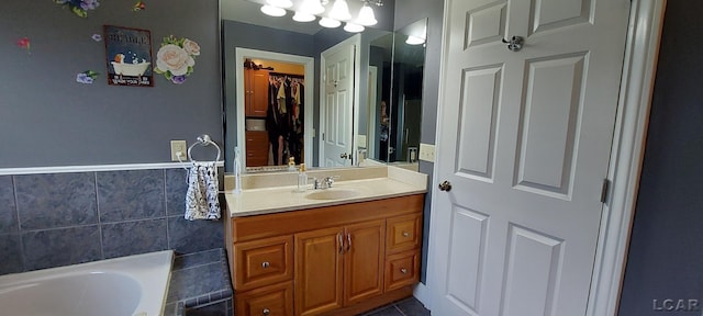 bathroom with vanity, a bath, and tile walls