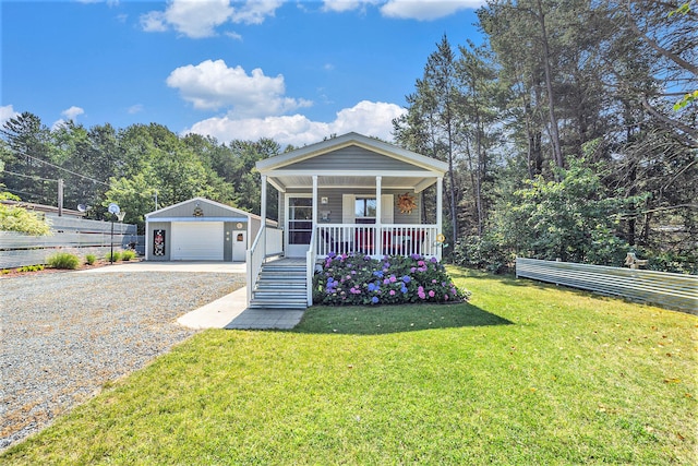 view of front of home featuring covered porch, a garage, an outdoor structure, and a front yard