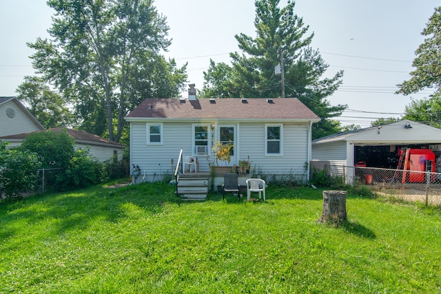 rear view of house featuring a lawn, an outdoor structure, and a garage