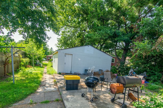 view of patio with a fire pit, an outdoor structure, and grilling area