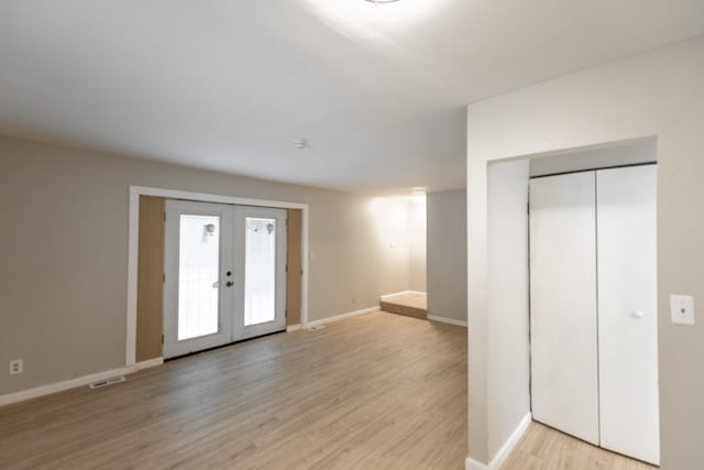 foyer entrance with light hardwood / wood-style floors, elevator, and french doors