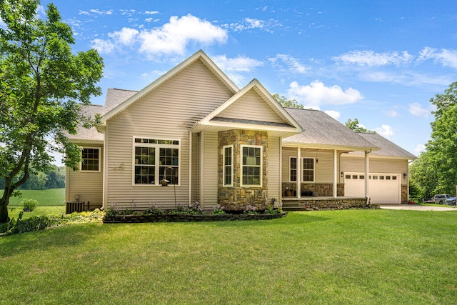 view of front of house with cooling unit, a garage, and a front yard