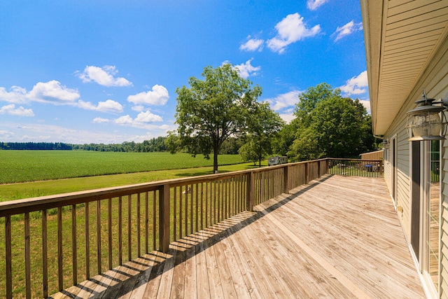 wooden terrace with a lawn and a rural view