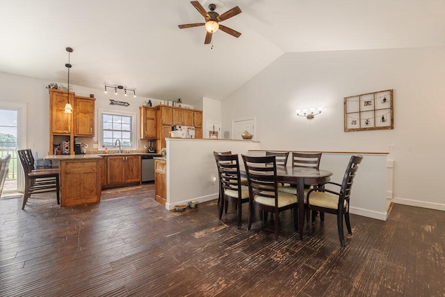 dining area featuring ceiling fan, sink, dark wood-type flooring, and vaulted ceiling