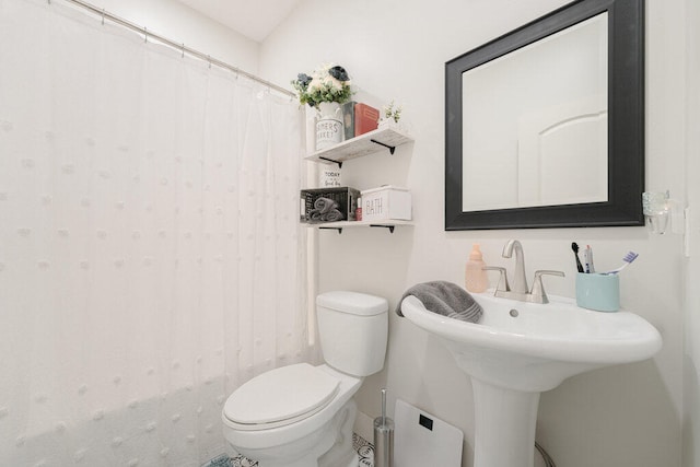 bathroom featuring a shower with shower curtain and toilet