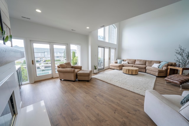 living room featuring a towering ceiling and wood-type flooring