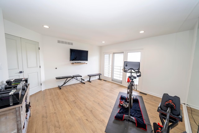 workout room with light hardwood / wood-style flooring