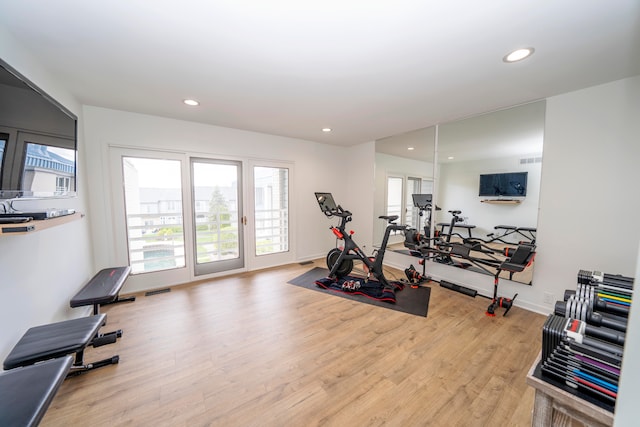 exercise room featuring light wood-type flooring