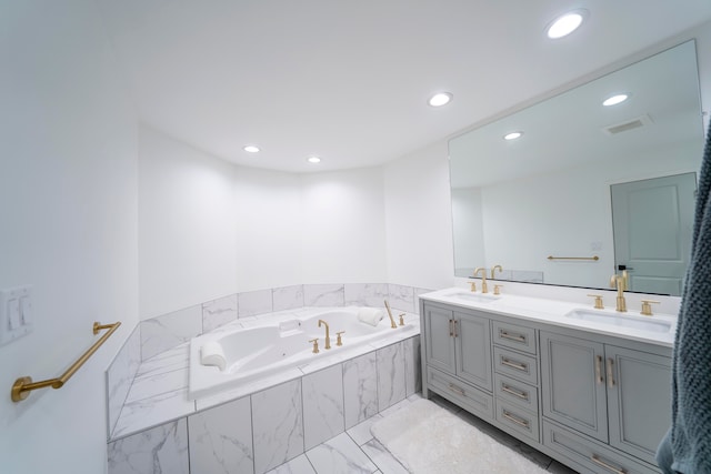 bathroom with vanity and tiled bath