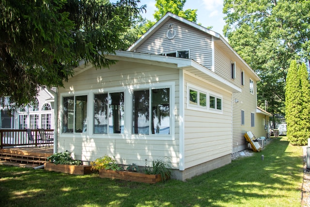 view of side of home with a yard and a wooden deck