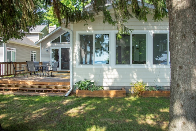 rear view of house with a deck and a lawn