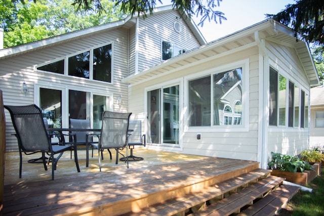 rear view of property featuring a deck and a sunroom