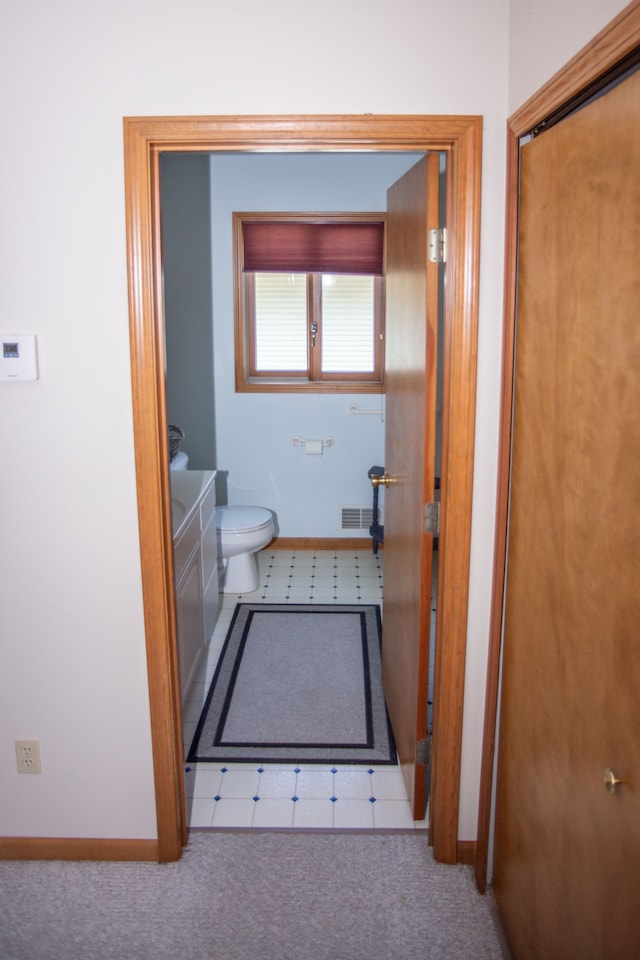 bathroom featuring toilet, baseboards, and visible vents