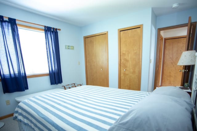 bedroom with multiple closets and baseboards