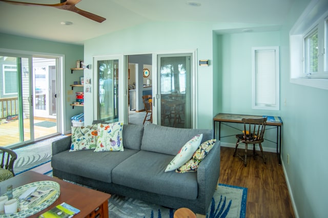 living room with a healthy amount of sunlight, vaulted ceiling, baseboards, and wood finished floors