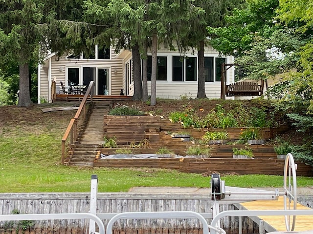 obstructed view of property featuring a front yard, stairway, and a wooden deck