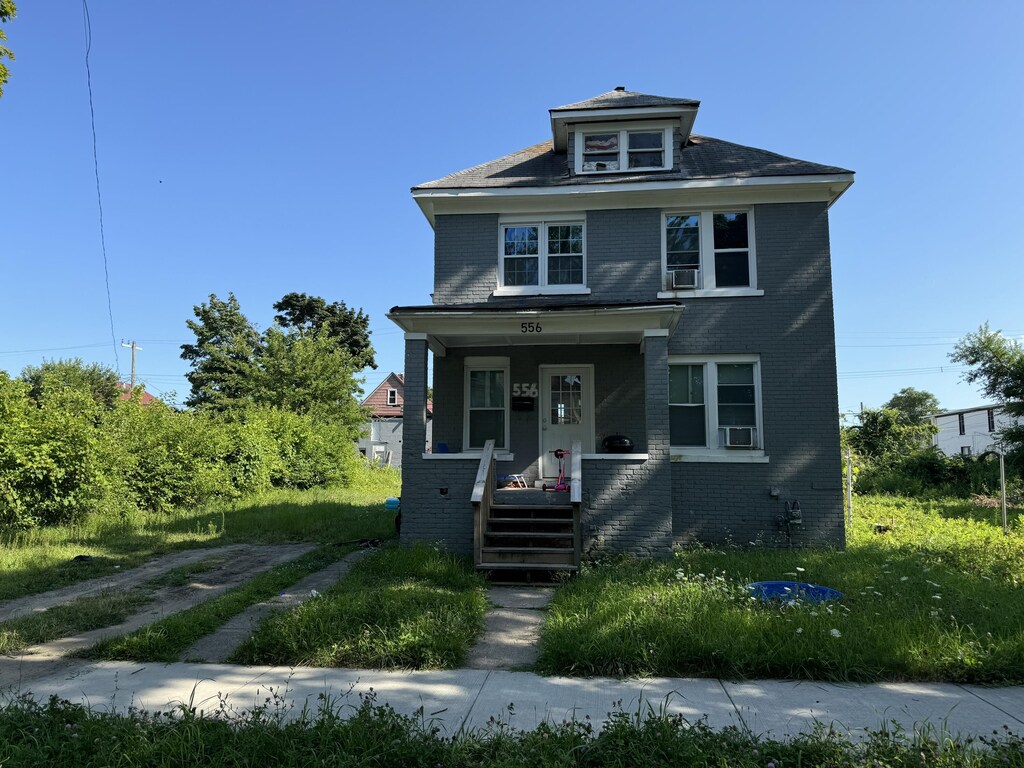 556 Leicester Ct, Detroit, MI 48202 - american foursquare style home with brick siding, covered porch, and cooling unit