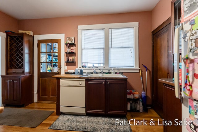 kitchen with white dishwasher, light hardwood / wood-style floors, dark brown cabinetry, and sink