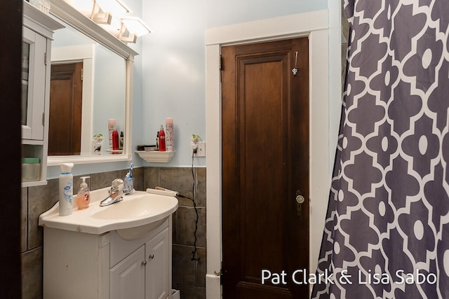 bathroom with vanity and tile walls