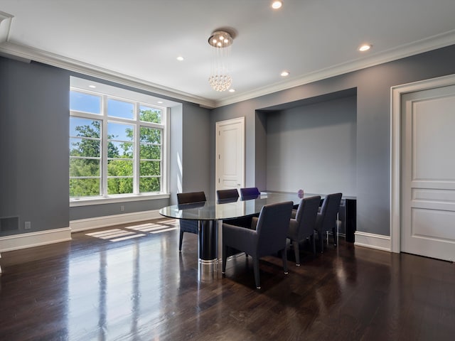 dining area with an inviting chandelier, dark wood-type flooring, and ornamental molding