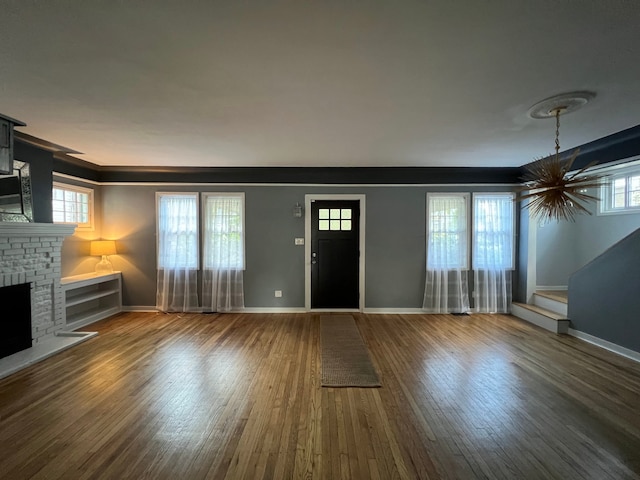 entryway featuring hardwood / wood-style flooring and a brick fireplace