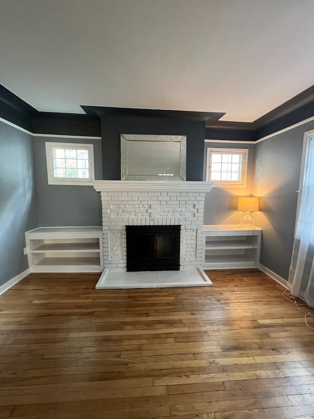 unfurnished living room featuring a healthy amount of sunlight, hardwood / wood-style floors, and a fireplace