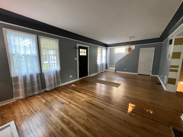 foyer entrance featuring wood-type flooring and a notable chandelier