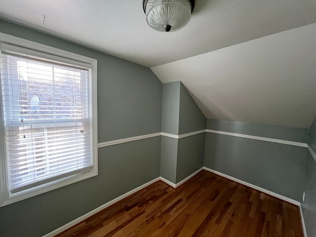 additional living space with lofted ceiling and dark wood-type flooring