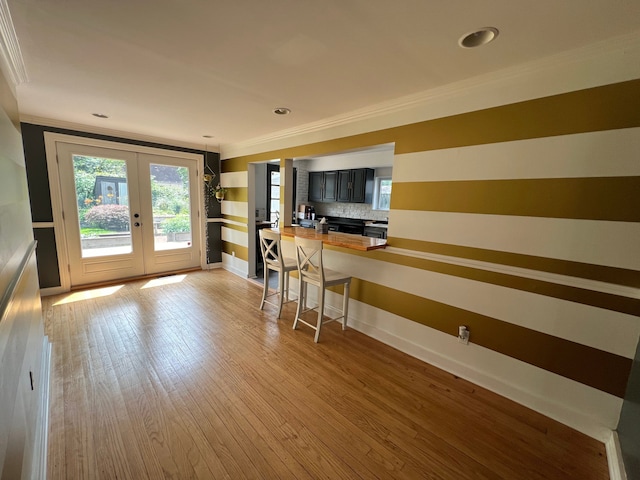 interior space featuring crown molding, butcher block counters, light hardwood / wood-style floors, decorative backsplash, and french doors