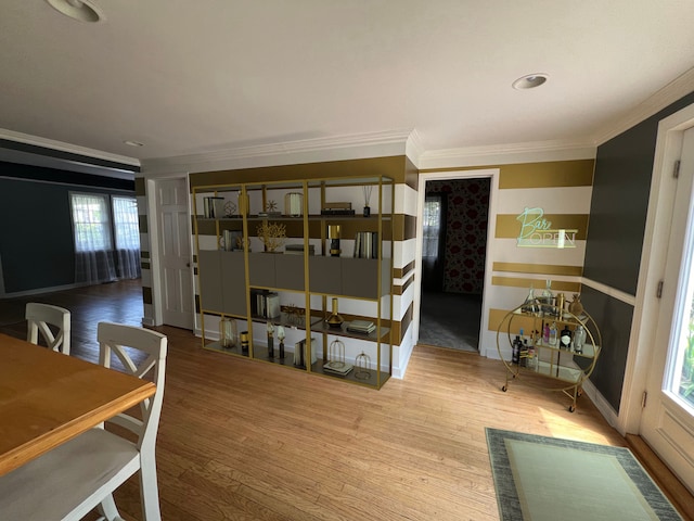 dining space with crown molding and hardwood / wood-style flooring