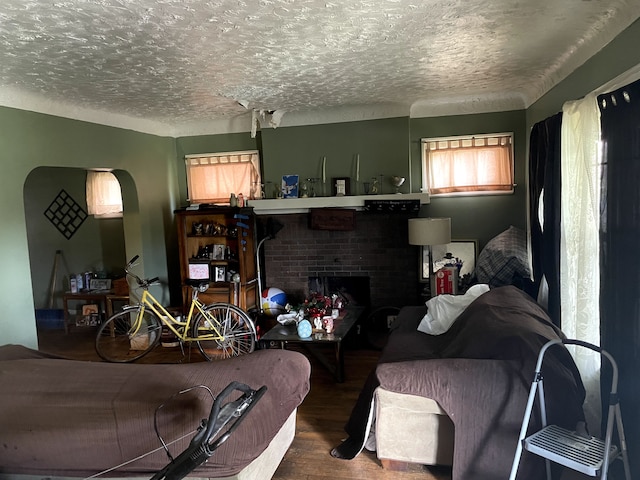 living room featuring a fireplace, wood-type flooring, and a textured ceiling